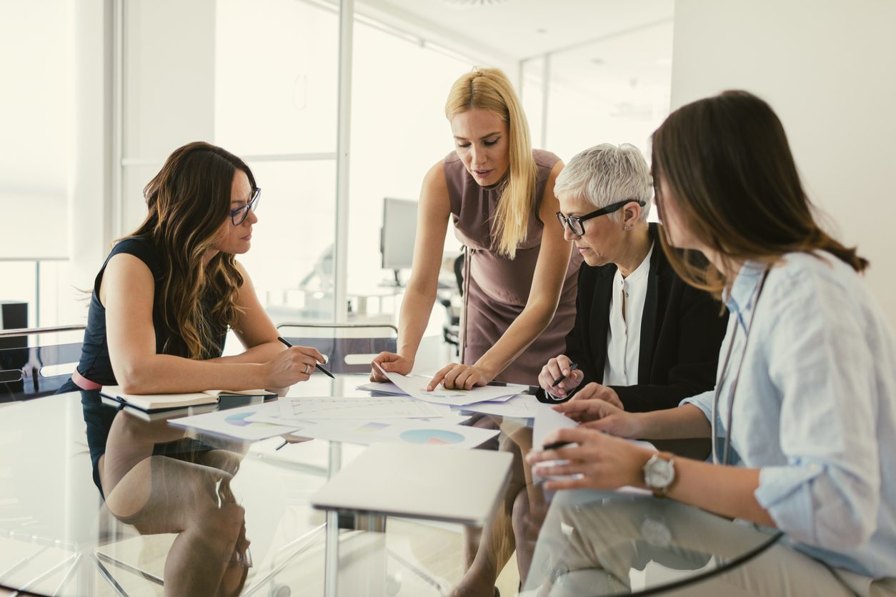 Women Working Together in The Office. Sitting by the desk and have business meeting