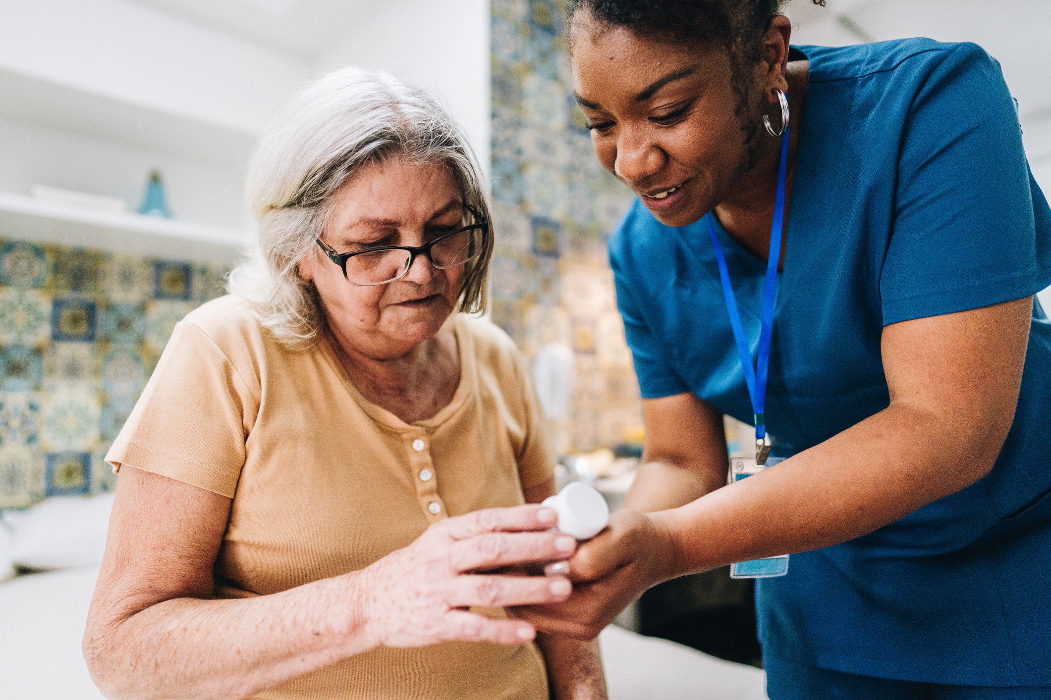 Nurse helping a patient with medication at home