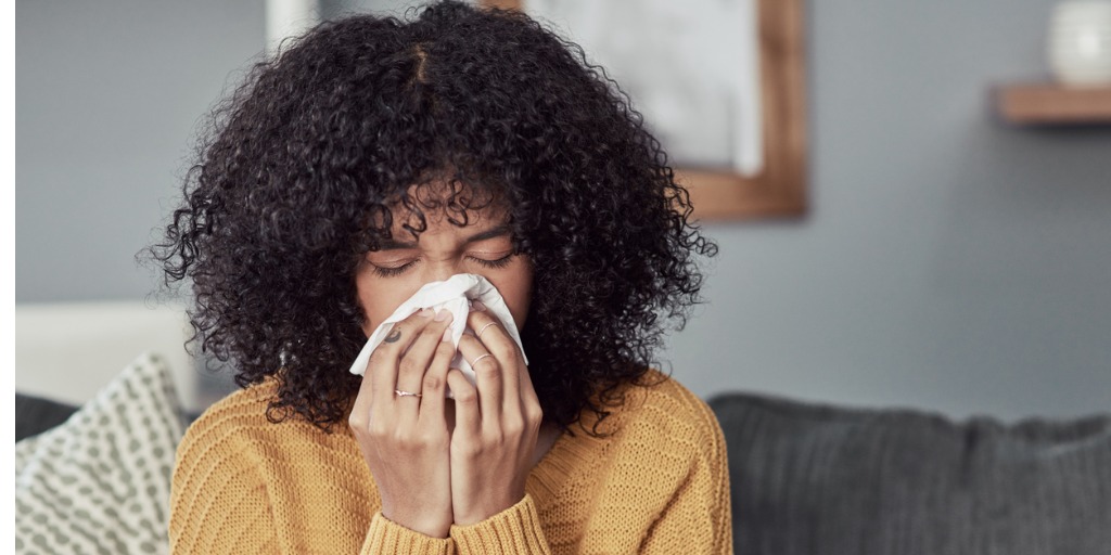 person sneezing into a tissue 