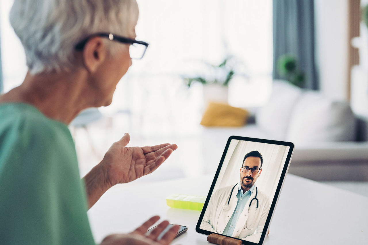 Woman on a telehealth call with her doctor on a tablet